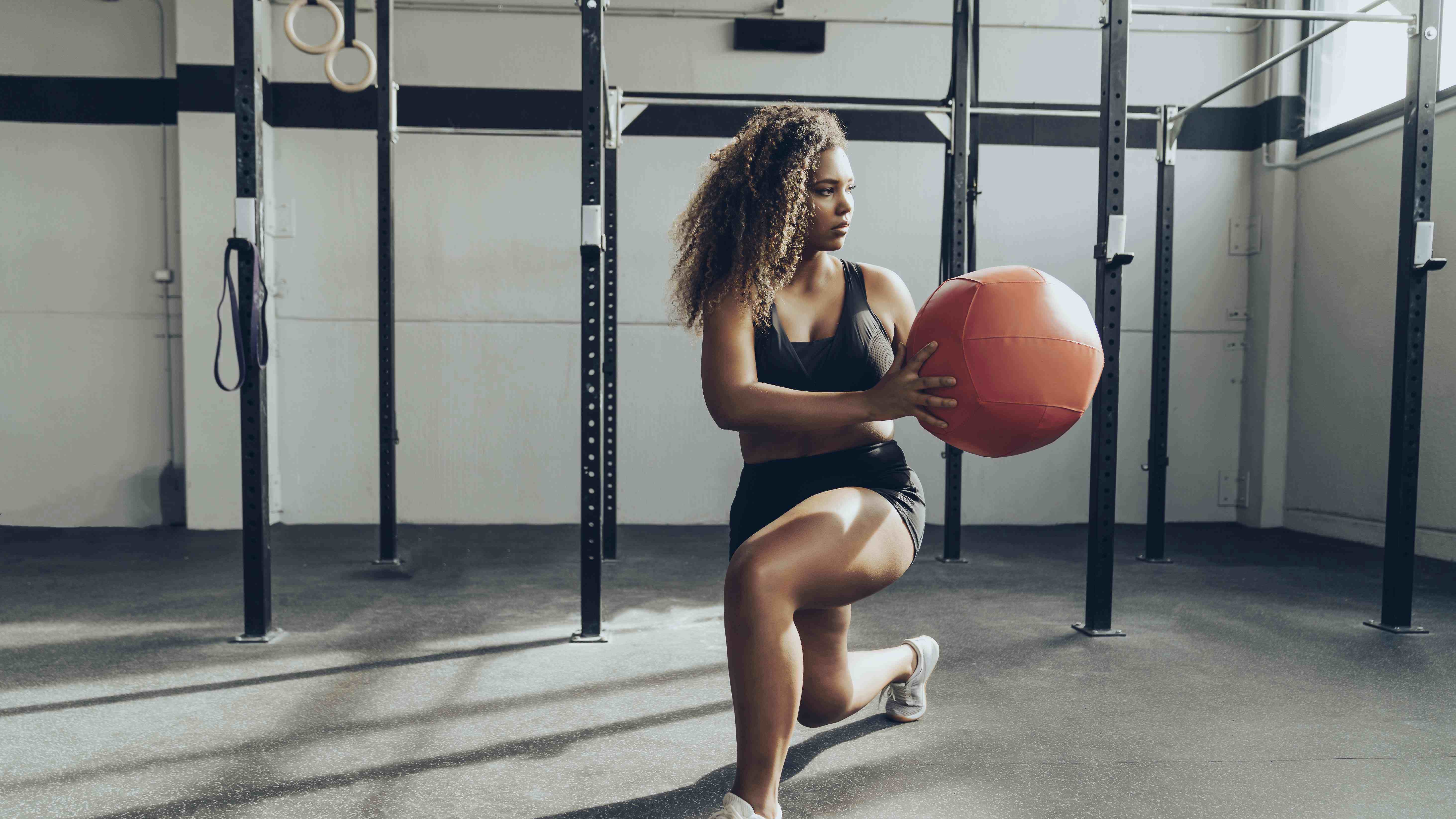 Young woman exercising with medicine ball in gym