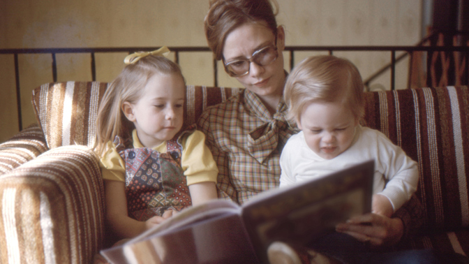 Mom and her little kids looking book