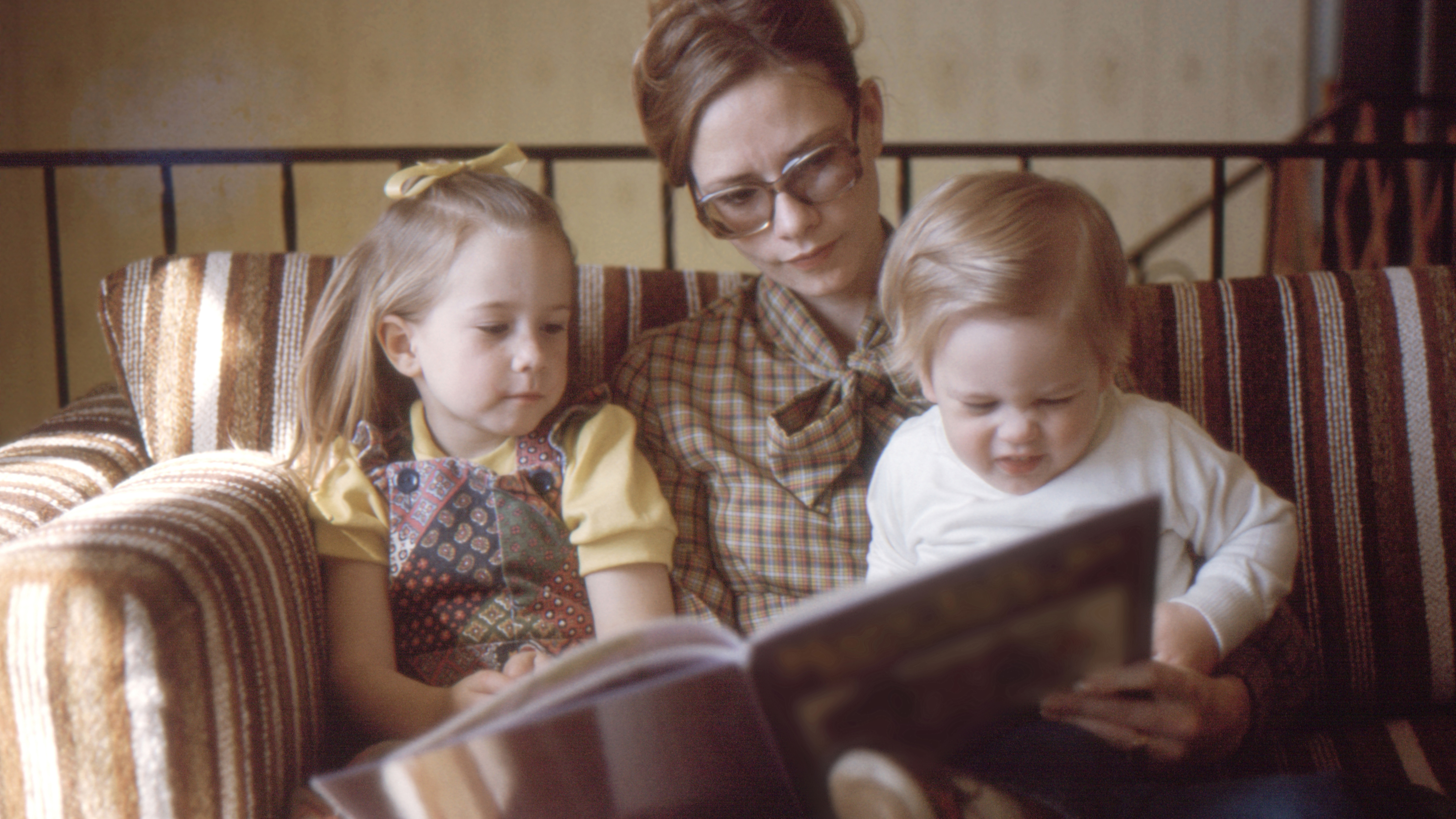 Mom and her little kids looking book