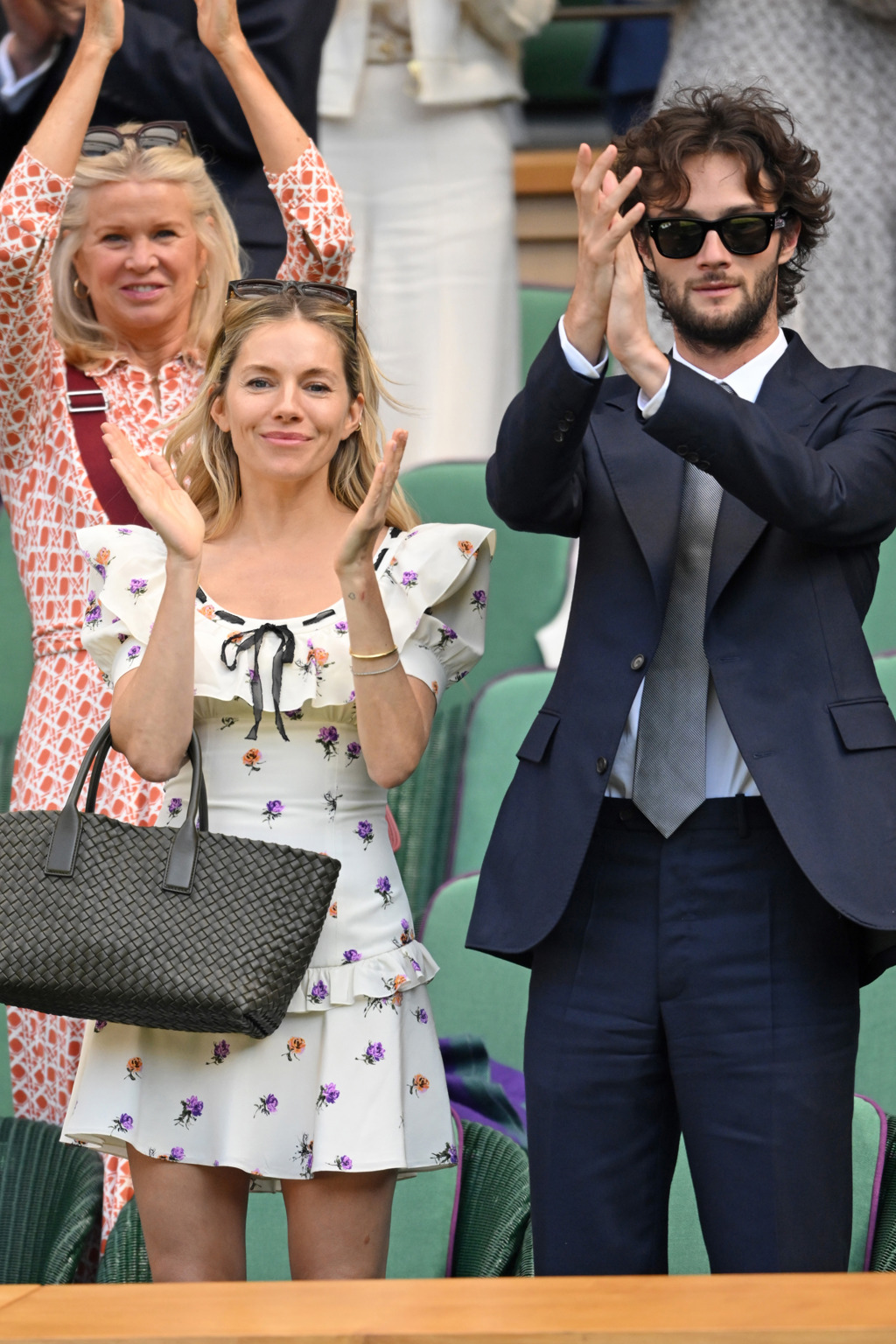  Sienna MillerHerečka na Wimbledon dorazila se svým partnerem Olim Greenem a oblékla květinové minišaty od Alessandry Rich a doplnila je černou proplétanou koženou taškou.