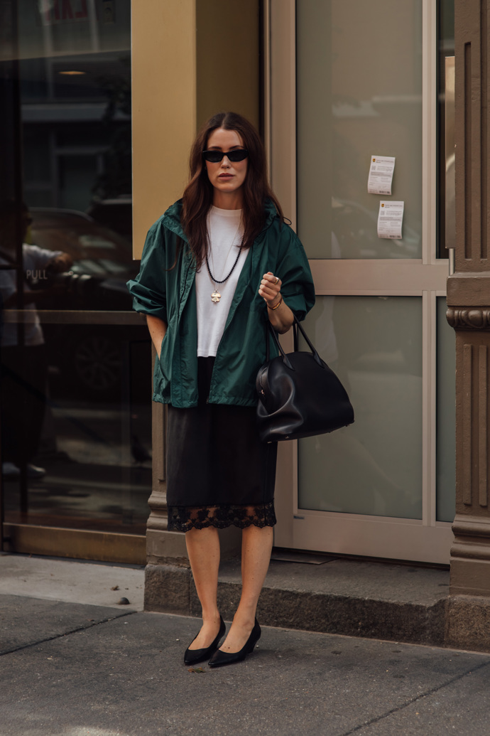 Bílé tričko, černá sukně s krajkou a černé lodičky – takový outfit může na první dobrou působit poměrně fádně. Fashion rozměr mu dodáte oversized bundou v tmavě zelené.