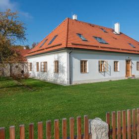 Hlavní budova si zvenku zachovává střídmý charakter venkovského domu s bílou fasádou, dřevěnými okny a výraznou sedlovou střechou s červenou krytinou