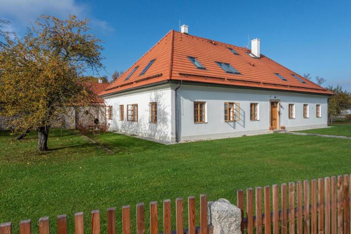 Hlavní budova si zvenku zachovává střídmý charakter venkovského domu s bílou fasádou, dřevěnými okny a výraznou sedlovou střechou s červenou krytinou