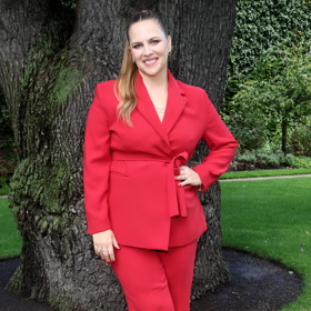 Petra Nesvačilová oblékla rudý kalhotový kostýmek se sakem na holém těle.
