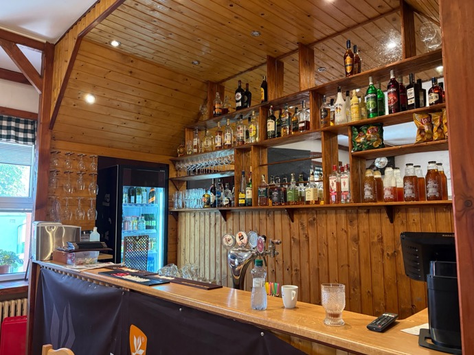 Pohled na bar hospůdky, který je kompletně zasazen do dřevěného obložení.