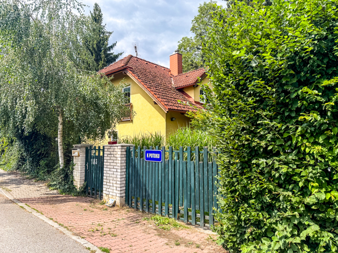 Domek je díky bujné zeleni ukrytý před zraky kolemjdoucích.