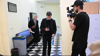 FOTO: Adam Kraus přichází k soudu začtený do mobilu.