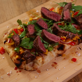 Hovězí steak na opečeném pita chlebu se zeleninou.