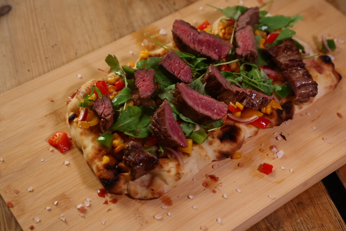 Hovězí steak na opečeném pita chlebu se zeleninou. 