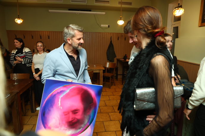 Spisovatel Rudolf Merkner obdržel během slavnostního křtu originální obraz, který ho viditelně potěšil.
