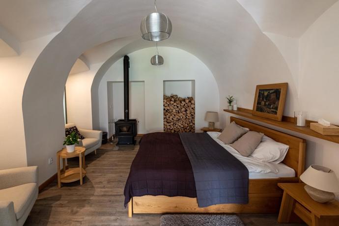 Oblé klenby se v ložnici opakují v několika vrstvách a vytvářejí jeden z nejvýraznějších architektonických motivů celého domu