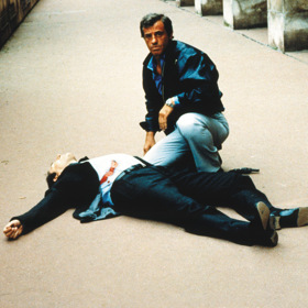 Jean-Paul Belmondo ve špionážním dramatu Profesionál. Ústřední hudební motiv, skladbu Chi Mai, složil Ennio Morricone.